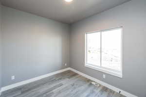Spare room featuring baseboards and light wood-style floors
