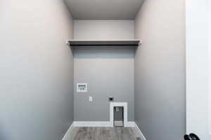 Laundry room featuring hookup for an electric dryer, washer hookup, and light wood-style floors