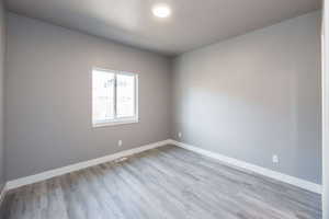 Unfurnished room featuring baseboards and light wood-type flooring
