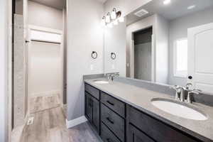 Bathroom featuring double vanity and light wood-type flooring