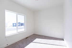 Empty room featuring light carpet and baseboards