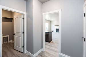 Hallway with light wood-style flooring and baseboards