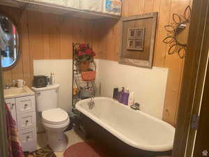 Bathroom featuring a freestanding bath, wooden walls, and vanity