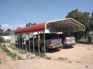 View of parking with a carport and dirt driveway