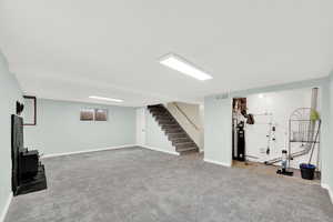 Basement with light colored carpet and a water softener