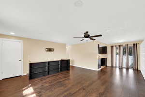Unfurnished living room with dark wood finished floors, ceiling fan, and recessed lighting