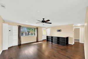 Unfurnished living room featuring dark wood finished floors, a ceiling fan, recessed lighting, and crown molding