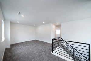 Spare room featuring dark carpet and recessed lighting