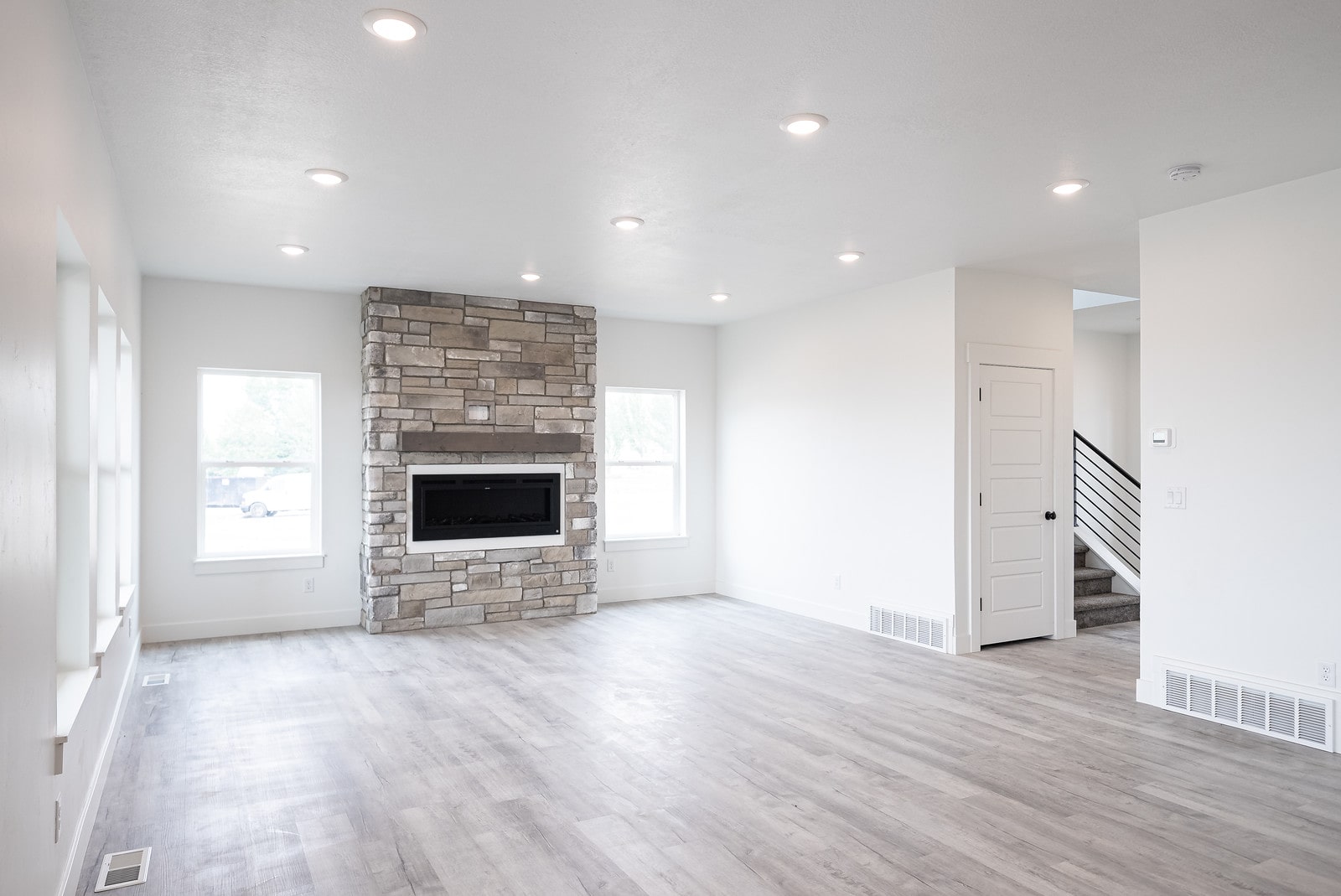 Unfurnished living room with light wood-style flooring, a fireplace, and recessed lighting