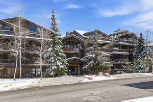 Snow covered building with a view of apartment building / complex