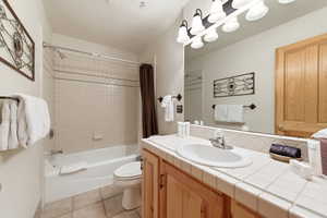 Full bathroom with vanity, shower / tub combo, and light tile patterned flooring