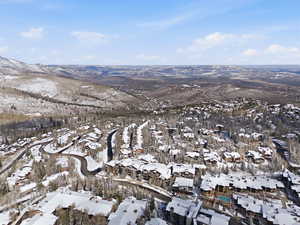 Snowy aerial view with a mountain view and a residential view