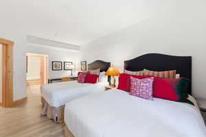 Bedroom with light wood-type flooring and ensuite bath