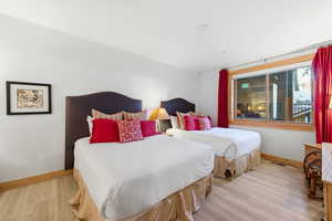 Bedroom with light wood-style floors and baseboards