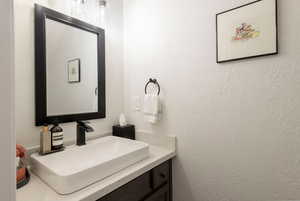 Bathroom featuring vanity and a textured wall