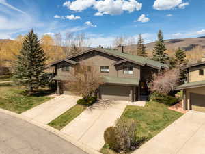 View of front of house featuring concrete driveway, an attached garage, and a front lawn