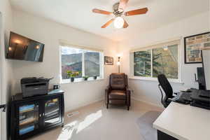 Office space featuring light carpet and ceiling fan