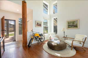 Sitting room featuring hardwood / wood-style floors and a high ceiling