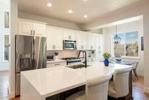 Kitchen featuring light wood-style floors, stainless steel appliances, and light stone counters