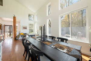 Dining space with hardwood / wood-style flooring and vaulted ceiling