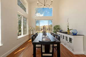 Dining space featuring a chandelier, dark wood-style floors, plenty of natural light, and vaulted ceiling