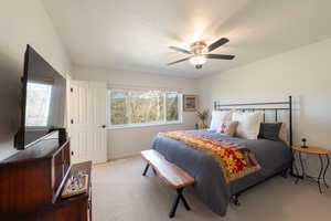 Carpeted bedroom with a ceiling fan and a textured ceiling