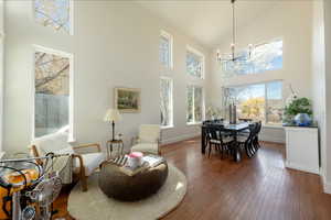 Dining space featuring dark wood-style flooring, lofted ceiling, and a chandelier