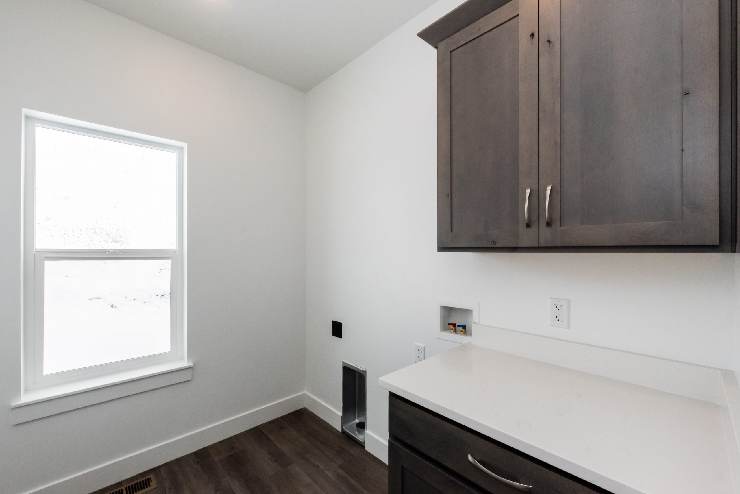 Laundry area featuring hookup for a washing machine, dark wood finished floors, cabinet space, and electric dryer hookup