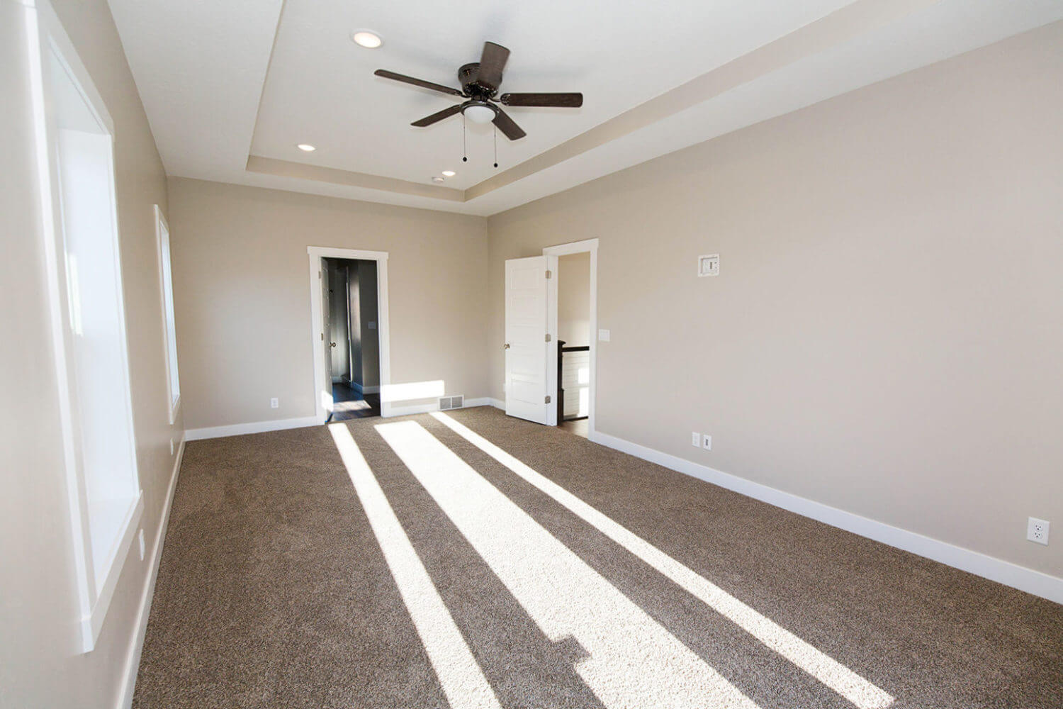 Unfurnished bedroom with carpet floors, recessed lighting, a ceiling fan, and a tray ceiling