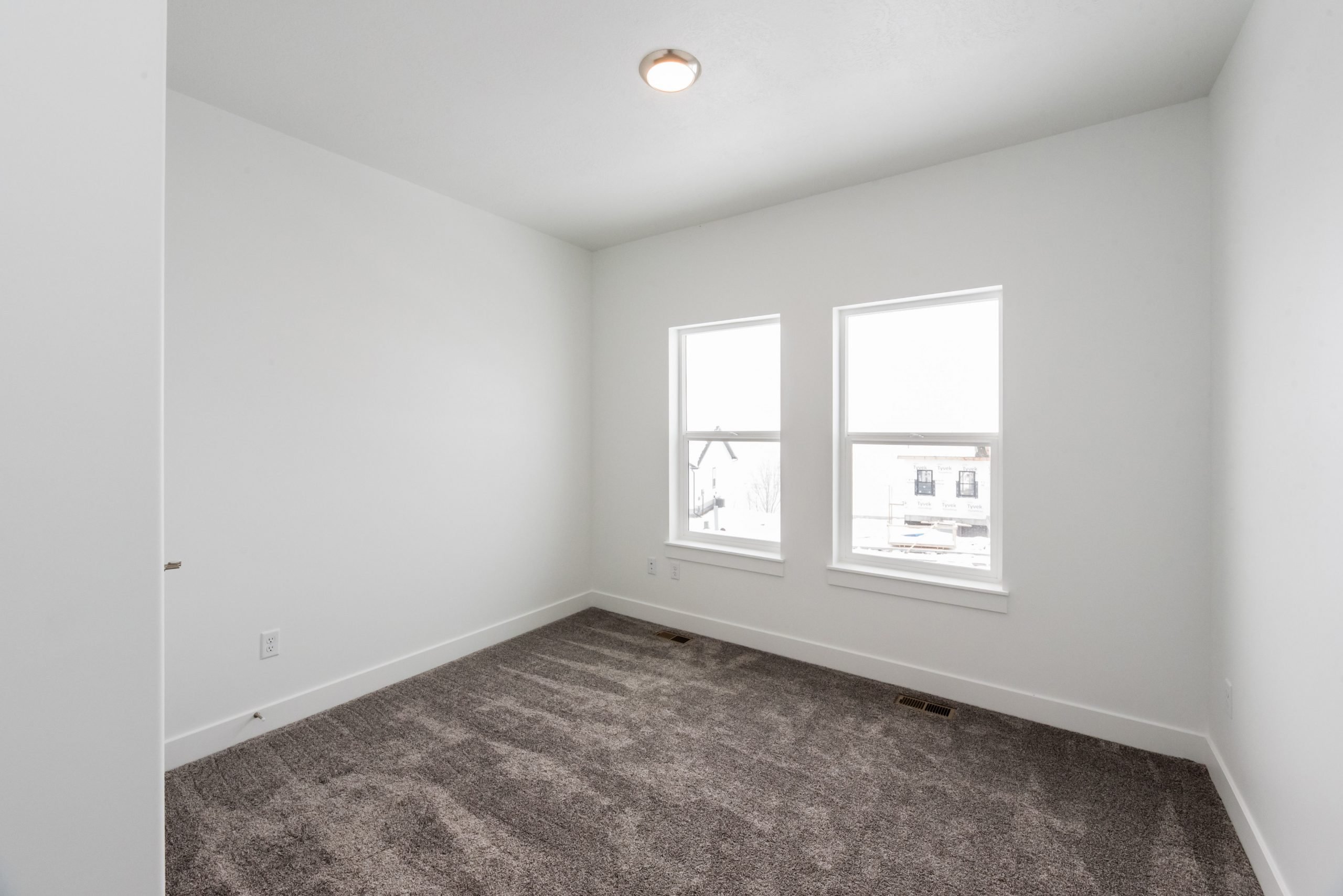 Unfurnished room with baseboards and dark carpet