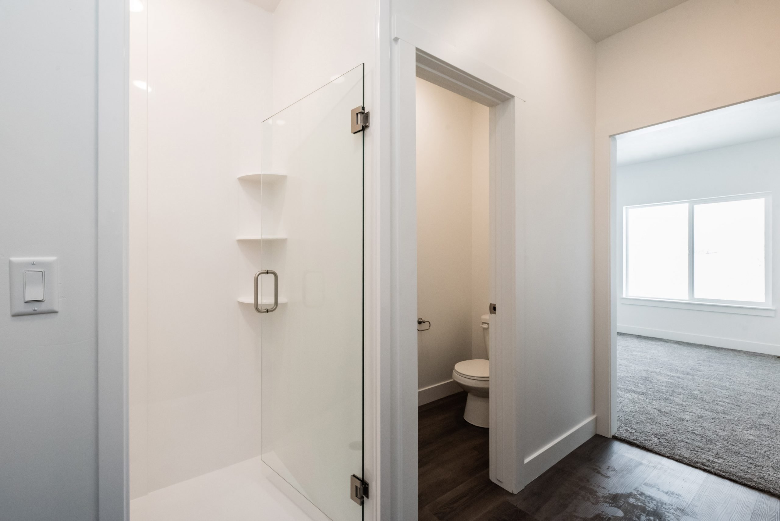 Bathroom with a shower stall and dark wood-style flooring