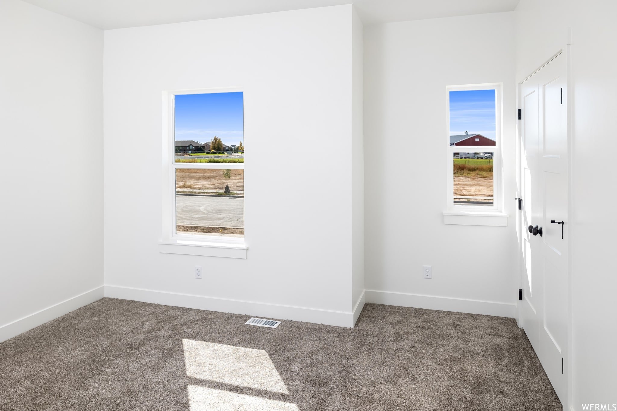 Carpeted empty room with baseboards