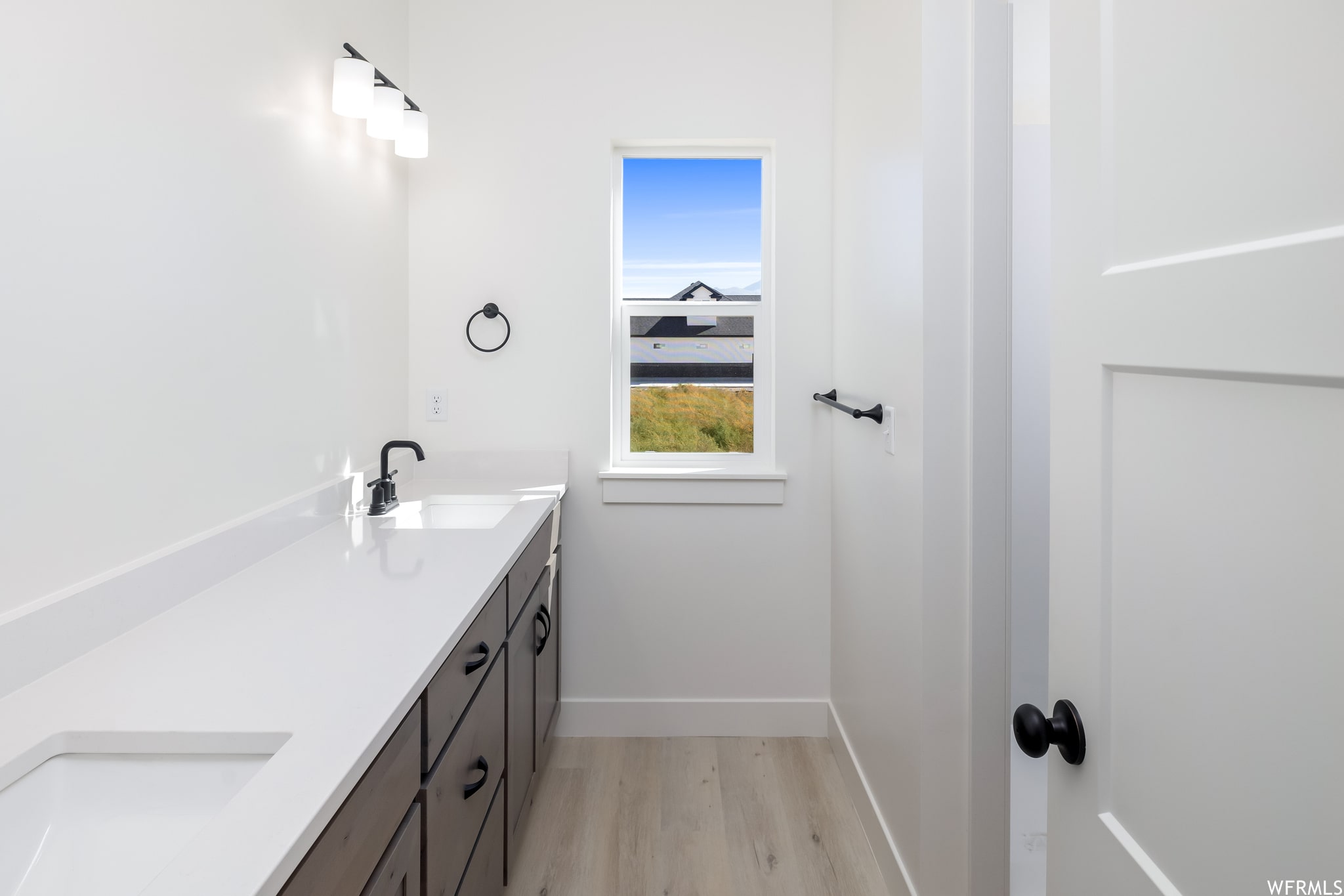 Bathroom with double vanity and light wood-style floors