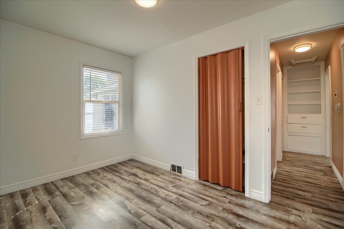 Unfurnished bedroom with light wood finished floors and baseboards