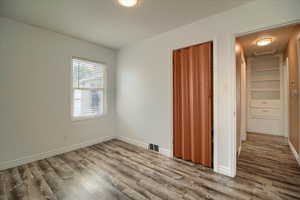 Unfurnished bedroom with light wood finished floors and baseboards