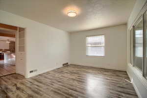 Spare room with wood finished floors and a textured ceiling