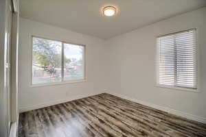 Unfurnished room featuring wood finished floors and plenty of natural light