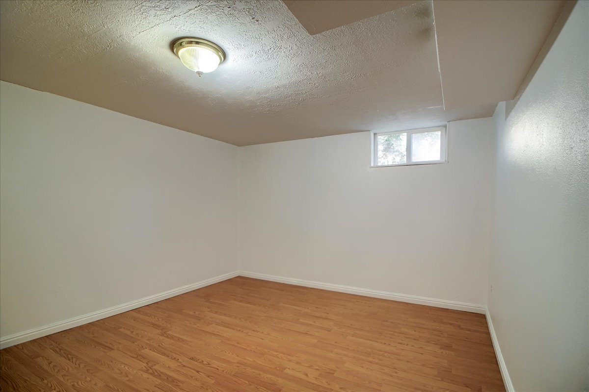 Below grade area with a textured ceiling and light wood-type flooring