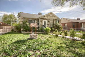 View of front of home featuring a chimney, stone siding, a detached garage, and an outdoor structure