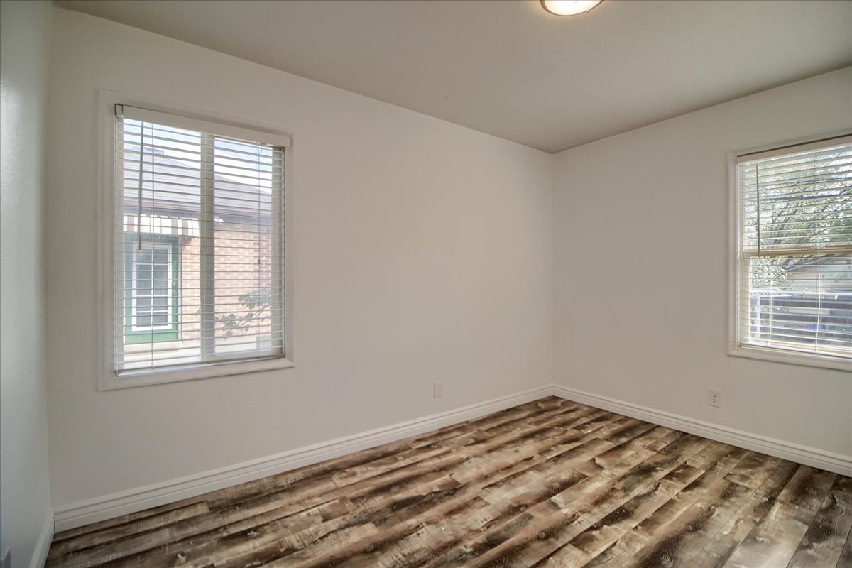 Unfurnished room with wood finished floors and baseboards