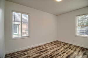Unfurnished room with wood finished floors and baseboards