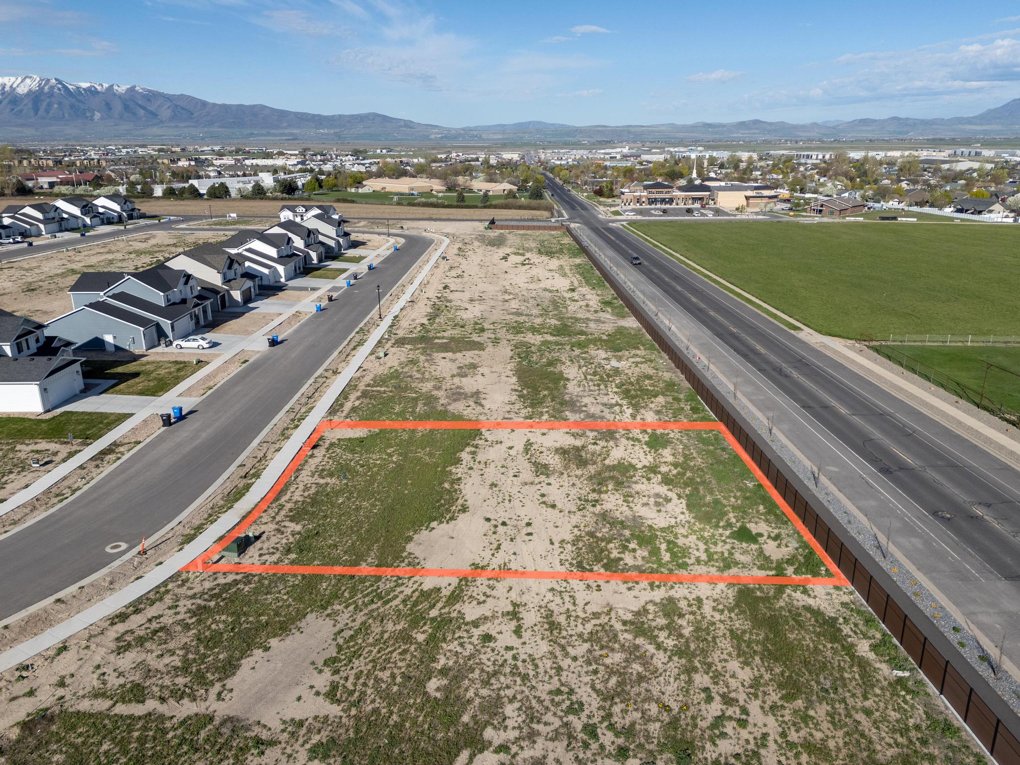 Aerial view of residential area featuring property boundaries highlighted and a mountainous background
