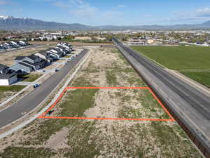 Aerial view of residential area featuring property boundaries highlighted and a mountainous background