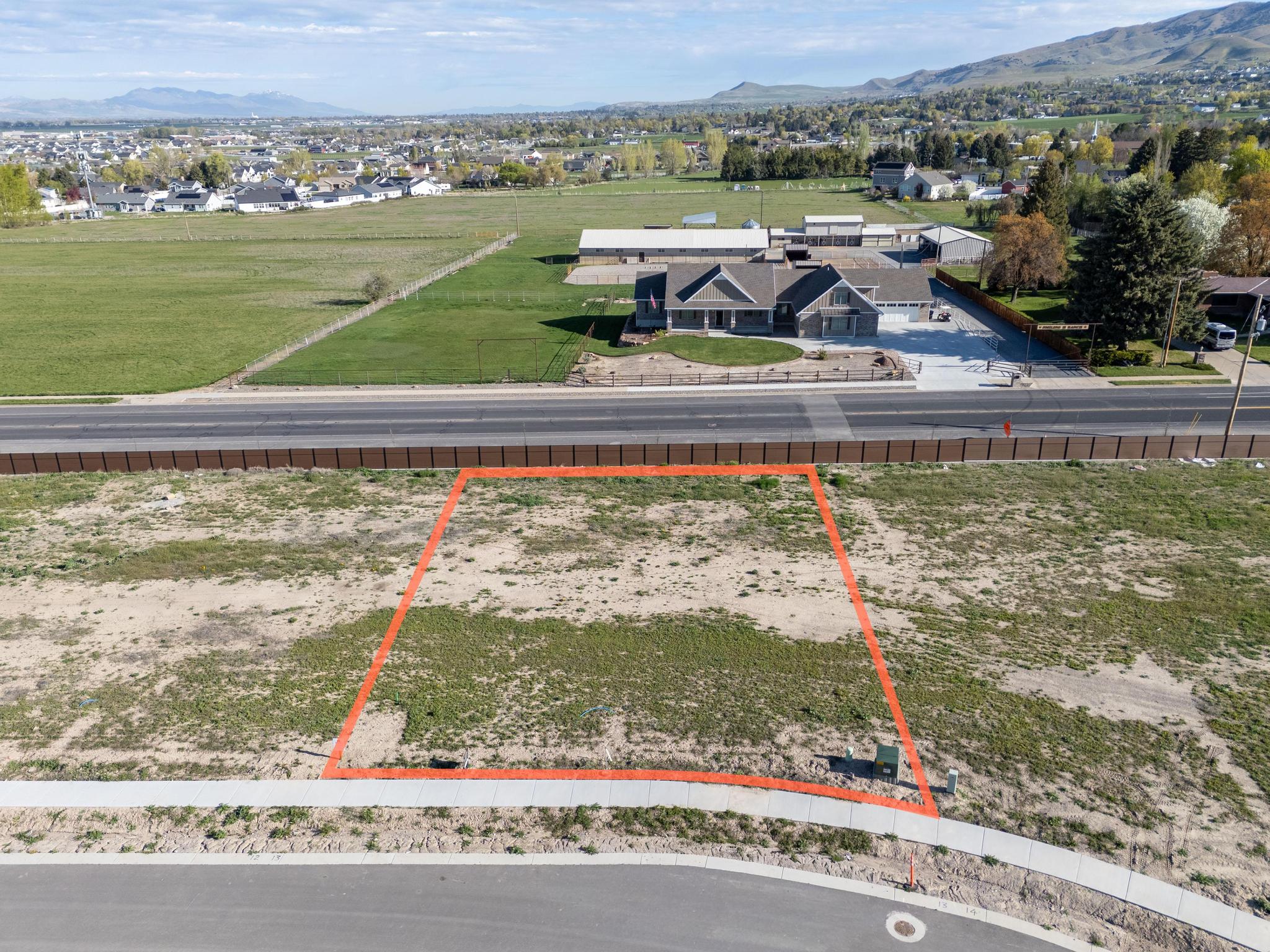 Aerial view of residential area with mountains and property parcel outlined