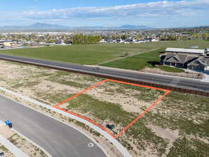 Aerial view of residential area with property parcel outlined and a mountain backdrop