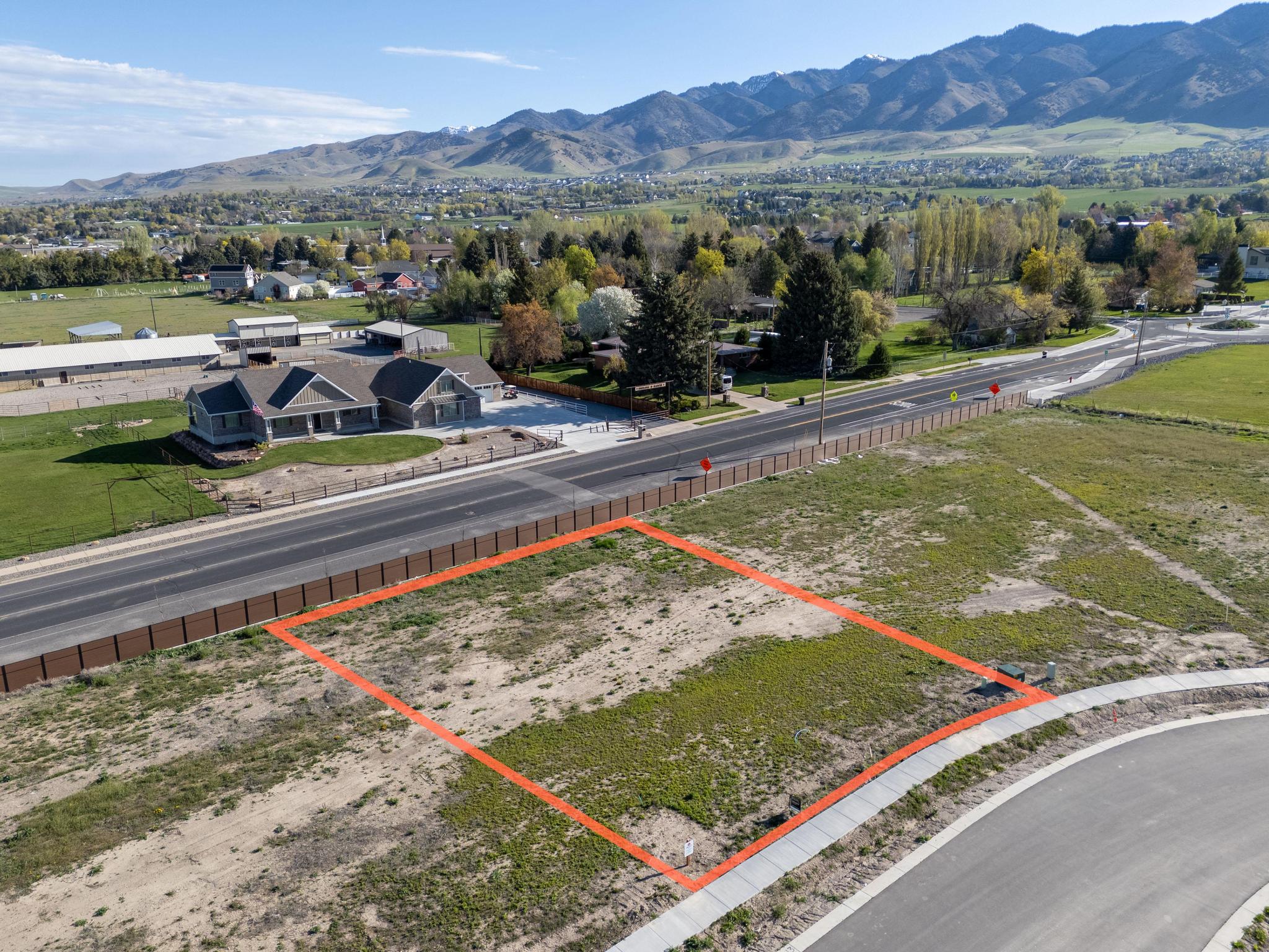 Aerial view of property and surrounding area featuring a mountain backdrop and property boundaries highlighted