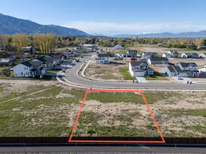 Aerial perspective of suburban area with property parcel outlined and a mountain backdrop