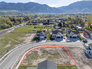 Aerial view of residential area featuring property parcel outlined and a mountain backdrop