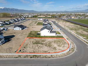 Aerial perspective of suburban area with property parcel outlined and mountains