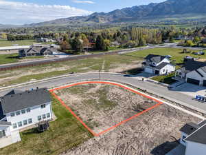 Aerial view of residential area with property boundaries highlighted and mountains